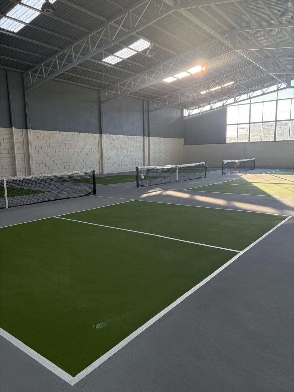 Canchas techadas de Zona Pickleball iluminadas por luz natural
